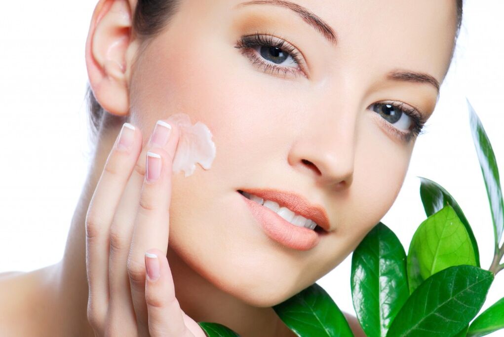 a girl applying a rejuvenating cream to her face